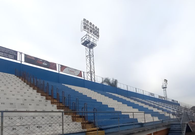Imagem dos refletores danificados do Estádio Schimitão, que enfrenta problemas de iluminação há anos.